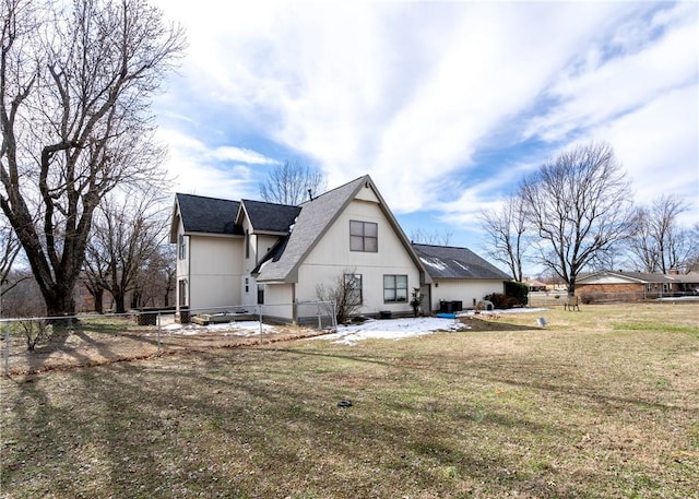 rear view of property with a yard and fence