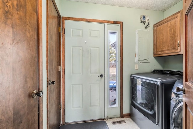 laundry area with a textured ceiling, visible vents, cabinet space, electric panel, and washing machine and clothes dryer