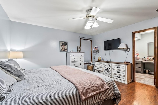 bedroom with a ceiling fan, connected bathroom, and wood finished floors