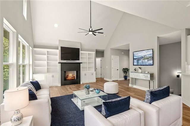 living room with ceiling fan, light hardwood / wood-style flooring, and high vaulted ceiling