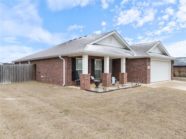 view of front facade with a front yard, a garage, and a porch