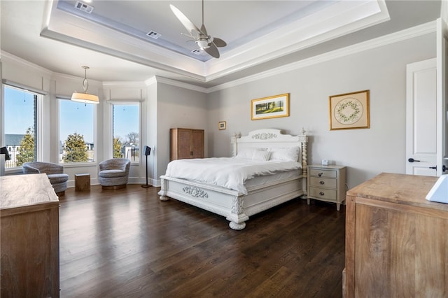 bedroom featuring crown molding, a tray ceiling, dark hardwood / wood-style flooring, and ceiling fan