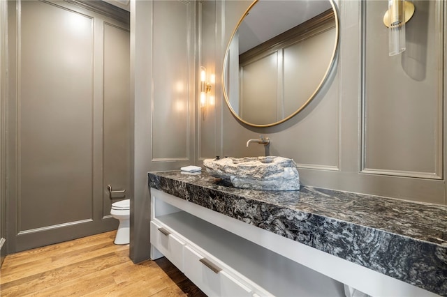 bathroom with toilet, hardwood / wood-style flooring, and vanity