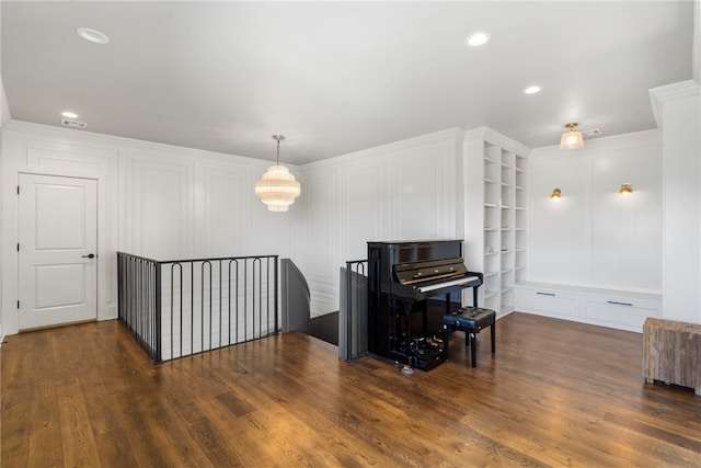 sitting room featuring ornamental molding, dark wood-type flooring, and built in features