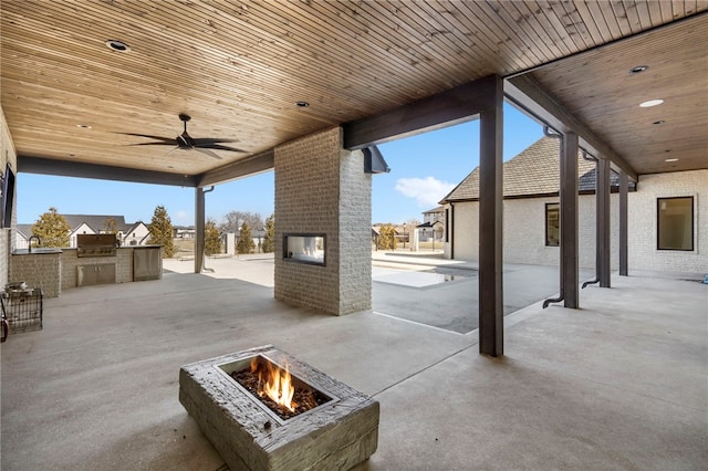 view of patio / terrace with ceiling fan, an outdoor kitchen, grilling area, and an outdoor fire pit