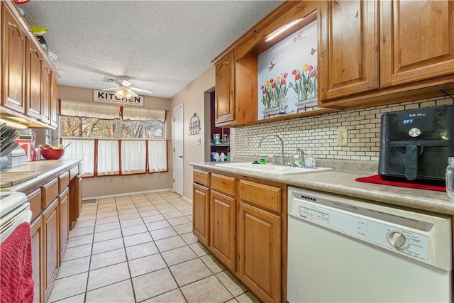 kitchen featuring light tile patterned floors, white appliances, a sink, a ceiling fan, and light countertops