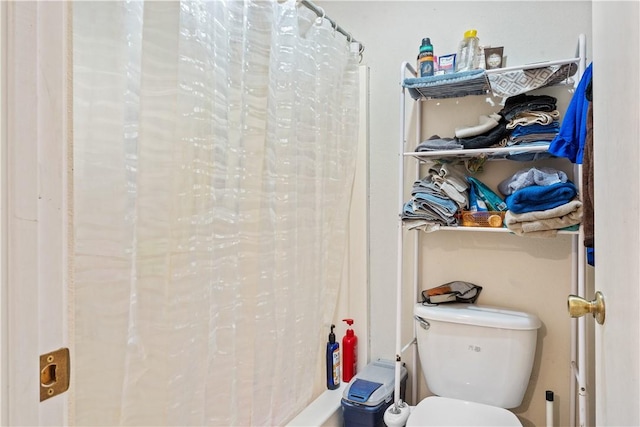 bathroom featuring toilet and curtained shower