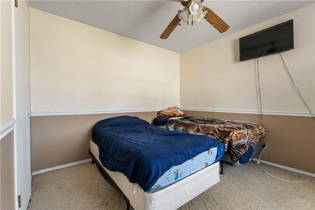 bedroom featuring baseboards, a textured ceiling, a ceiling fan, and carpet flooring