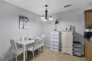 dining room featuring baseboards, an inviting chandelier, visible vents, and light tile patterned floors