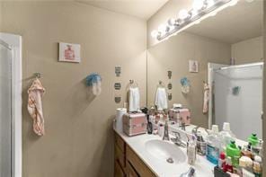 full bath featuring vanity and a shower stall