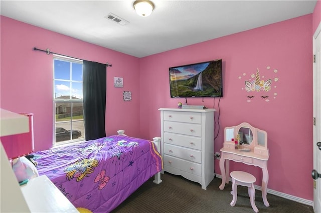 bedroom with baseboards, visible vents, and dark carpet