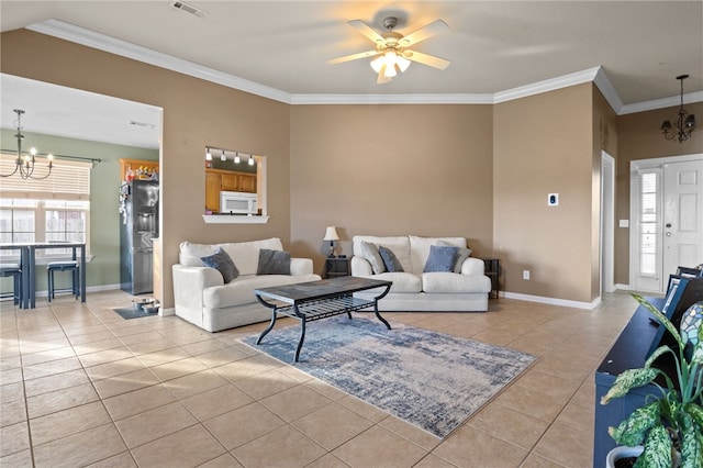 living area featuring light tile patterned flooring, ceiling fan with notable chandelier, visible vents, baseboards, and crown molding