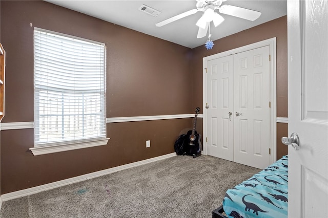 unfurnished bedroom featuring baseboards, visible vents, ceiling fan, carpet flooring, and a closet