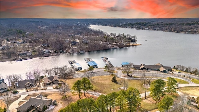 aerial view at dusk featuring a water view