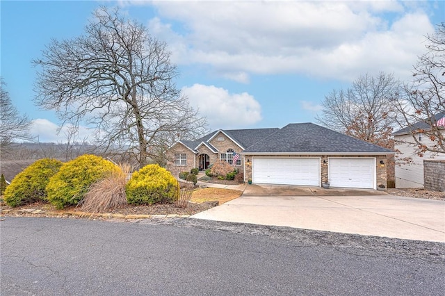 view of front facade with a garage, driveway, and a shingled roof