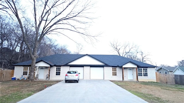 ranch-style home featuring a garage, fence, concrete driveway, and brick siding