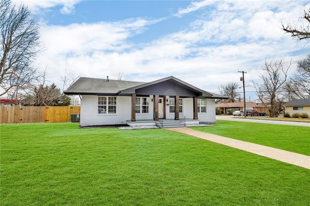 view of front of home featuring fence, a front lawn, and central AC