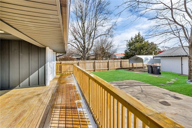 wooden terrace featuring a fenced backyard and a yard