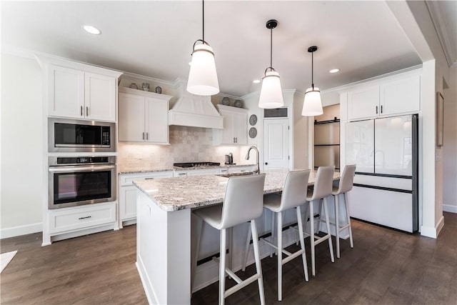 kitchen with dark wood-style flooring, stainless steel appliances, white cabinetry, crown molding, and backsplash