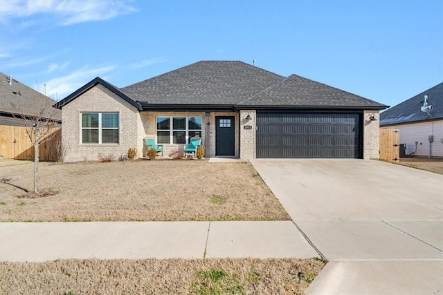 view of front of home with concrete driveway, brick siding, and an attached garage