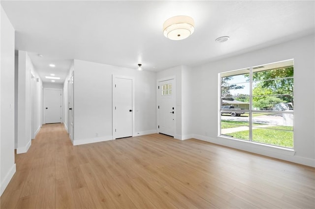 spare room featuring light wood-style floors and baseboards