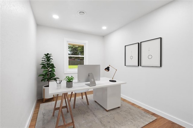 office space with baseboards, recessed lighting, visible vents, and light wood-style floors