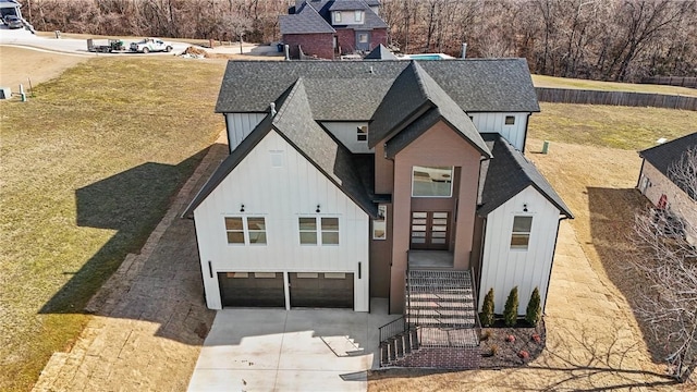 modern farmhouse style home featuring driveway, a shingled roof, a garage, and board and batten siding