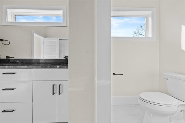 bathroom featuring toilet, tile patterned flooring, and vanity