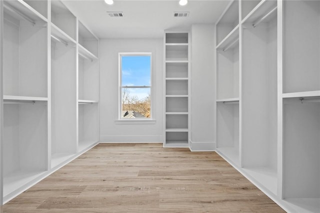 spacious closet with light wood-style floors and visible vents