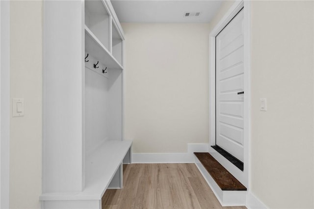 mudroom with baseboards, visible vents, and light wood finished floors