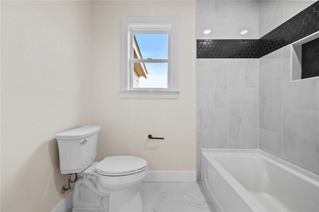 bathroom with marble finish floor, shower / bath combination, toilet, and baseboards