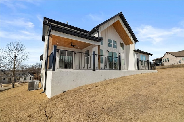 rear view of house with ceiling fan, a yard, cooling unit, and a residential view