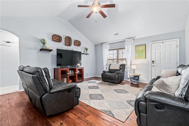 living area with visible vents, arched walkways, a ceiling fan, lofted ceiling, and wood finished floors