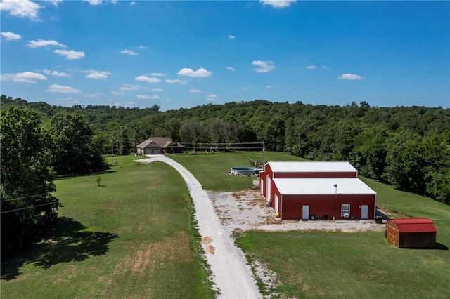 bird's eye view with a wooded view