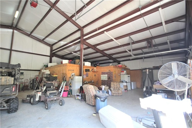 garage featuring freestanding refrigerator and metal wall