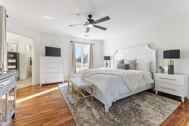 bedroom with ceiling fan, wood finished floors, and visible vents