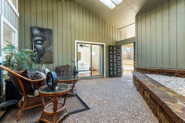 exterior space featuring high vaulted ceiling and wood walls