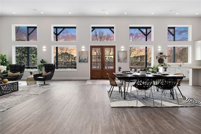 dining area featuring recessed lighting, a high ceiling, baseboards, and wood finished floors