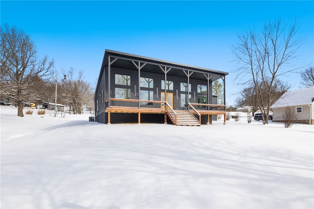 view of front of property with stairway and a sunroom