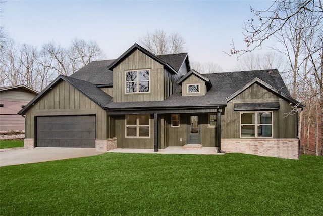 view of front of house with brick siding, roof with shingles, concrete driveway, a garage, and a front lawn