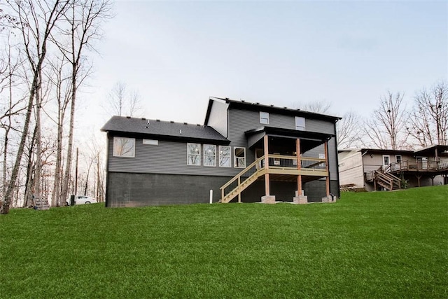 back of property featuring stairway, a wooden deck, and a lawn