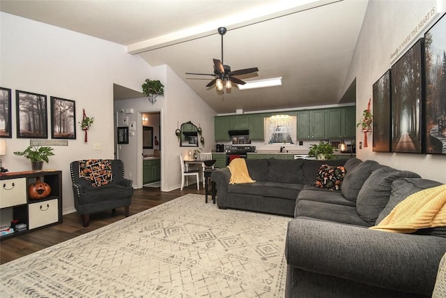 living room with vaulted ceiling with beams, wood finished floors, a ceiling fan, and baseboards