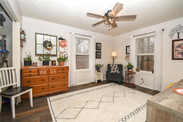 sitting room featuring dark wood finished floors and a ceiling fan