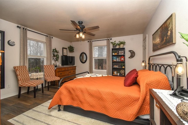 bedroom with dark wood finished floors, a ceiling fan, and baseboards