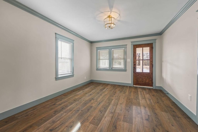 foyer entrance with ornamental molding, dark wood finished floors, and baseboards