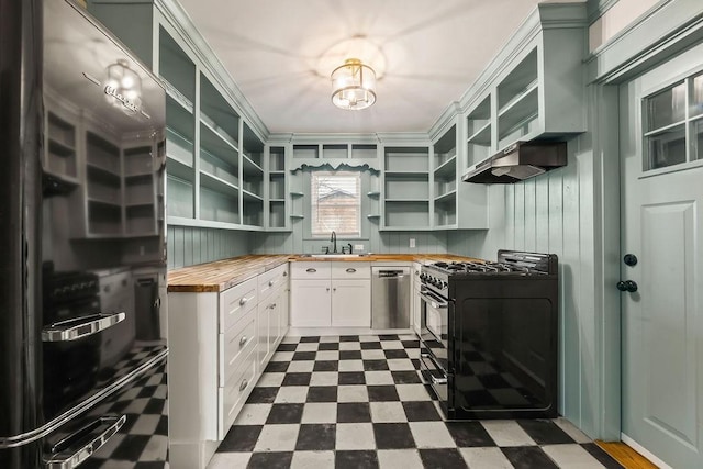 kitchen with black gas stove, dark floors, glass insert cabinets, and wooden counters