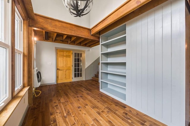 interior space featuring stairs, wood finished floors, beam ceiling, and heating unit