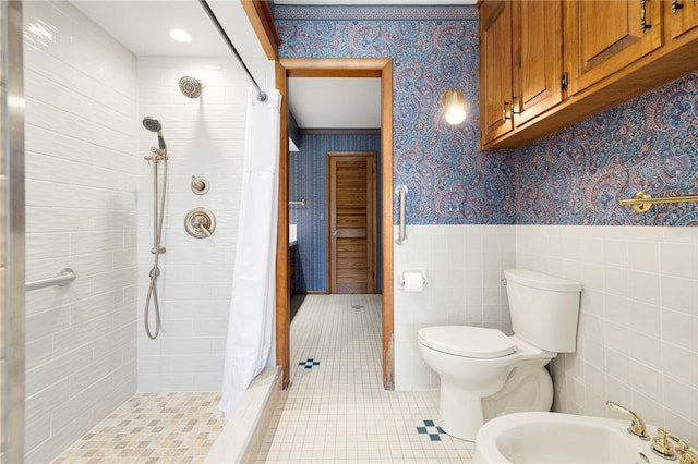 full bath with a bidet, a wainscoted wall, tile patterned floors, a stall shower, and wallpapered walls