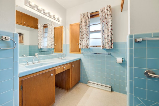 bathroom featuring a wainscoted wall, a sink, tile walls, and double vanity