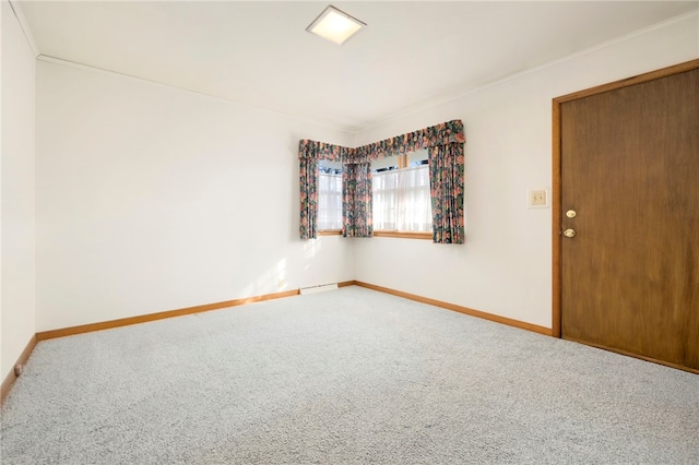 carpeted empty room with baseboard heating and baseboards